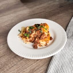 Plate of stuffed rigatoni bake with creamy ricotta filling, hearty meat sauce, and melted cheese, baked to golden perfection—a comforting Italian dish.