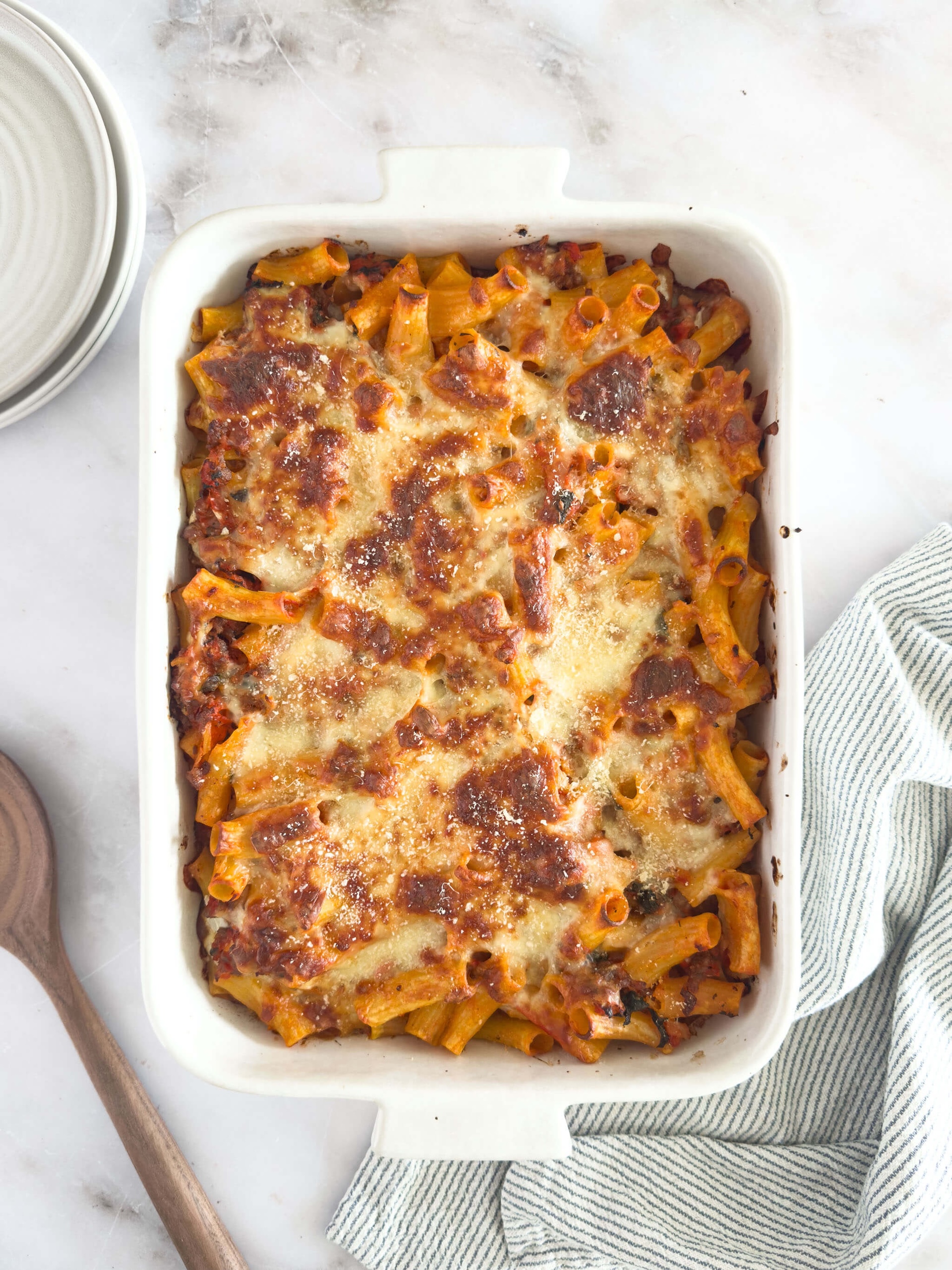 Pan of gluten-free baked ziti with creamy, cheesy tomato sauce, Italian sausage, and fresh mozzarella cheese, topped with a golden brown, crispy crust.