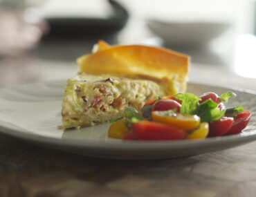 Plate with slice of Gluten-Free Quiche Lorraine and side salad