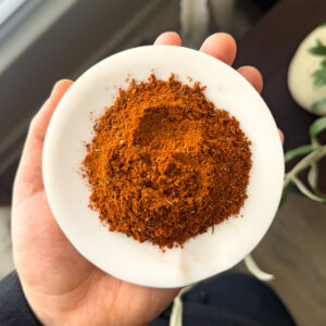 Gluten-free Cajun seasoning spice blend in a small white dish held in hand
